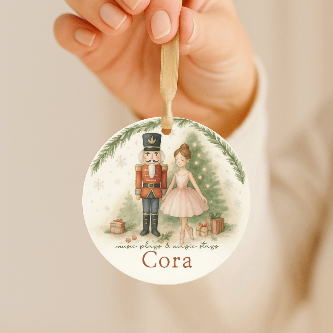 Personalized Christmas ornament with ballerina and nutcracker hanging by a gold ribbon