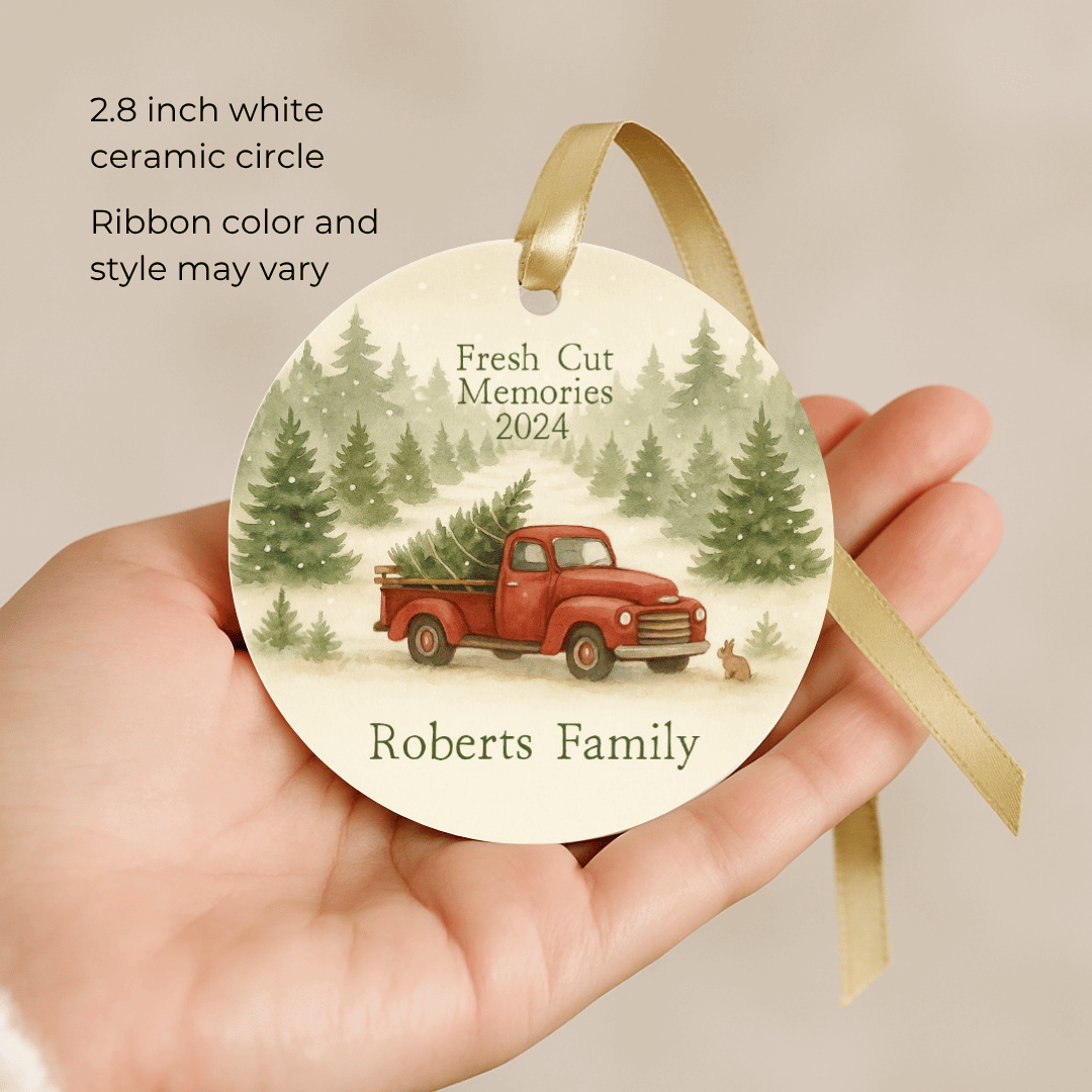 Round ceramic ornament with red truck and trees design, held in a hand with text about product details.