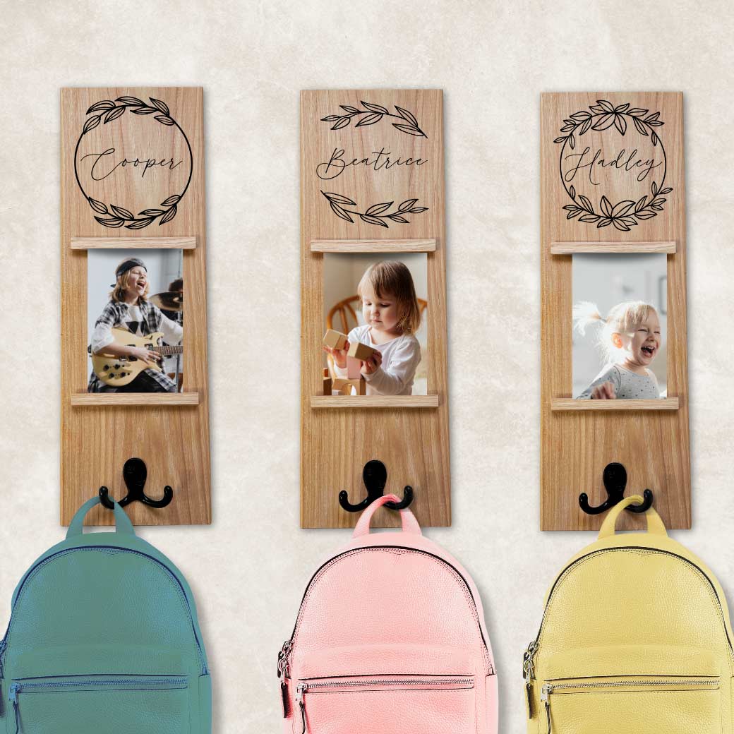 Wall-mounted coat rack with printed name design and photo slot for personalized home organization.