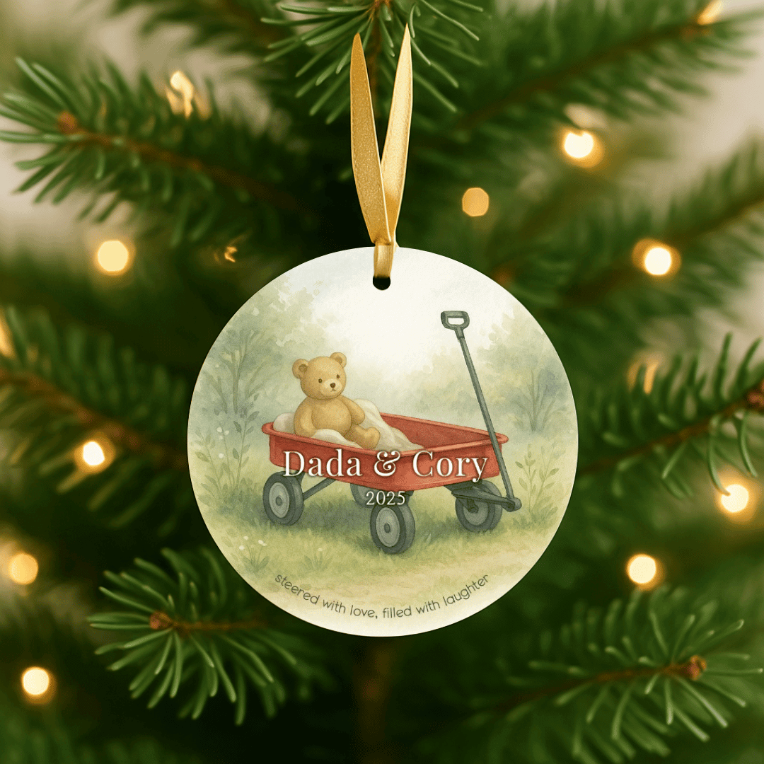 Personalized ceramic Christmas ornament with a teddy bear in a red wagon on a tree with lights.