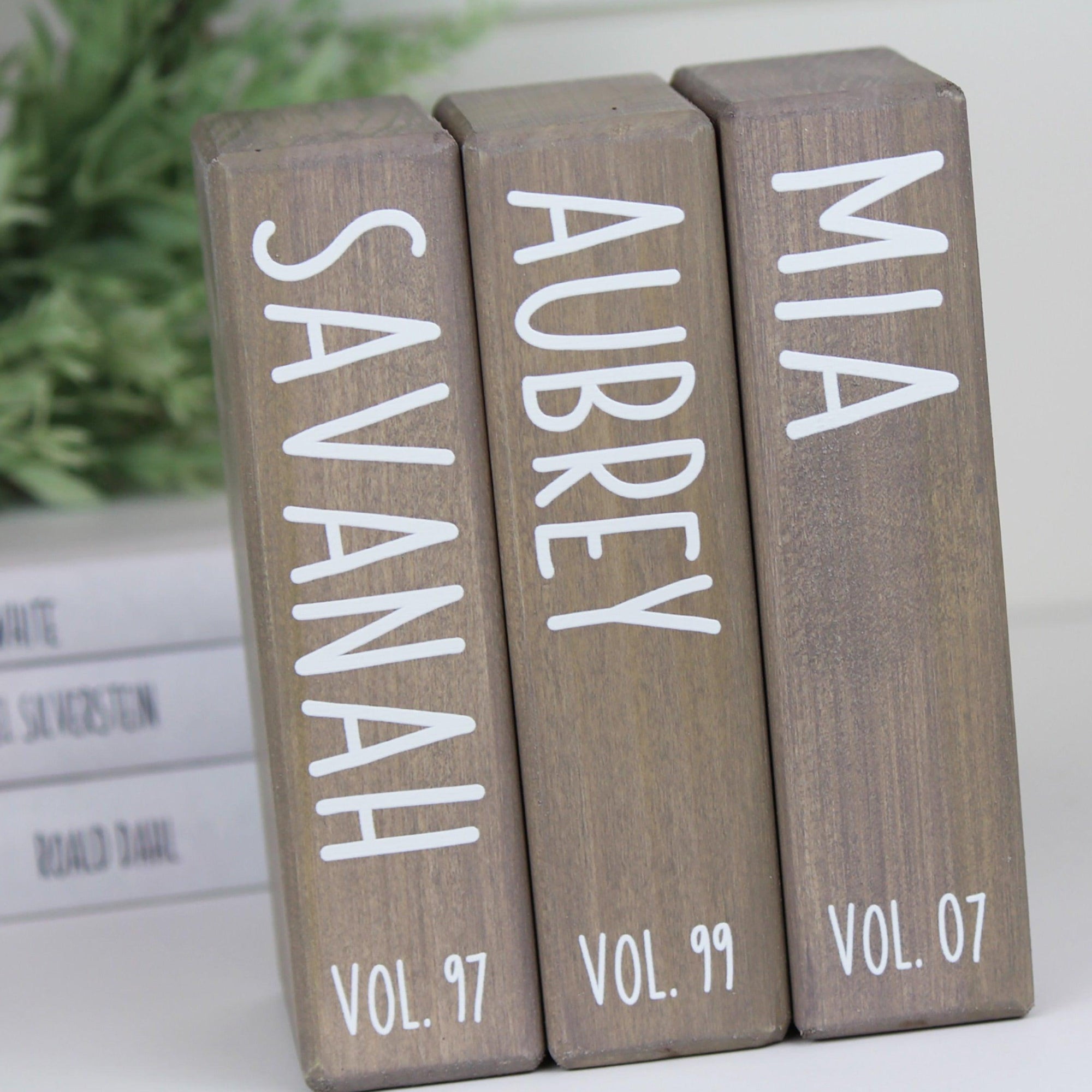 Stack of wooden family books personalized with names and birth years