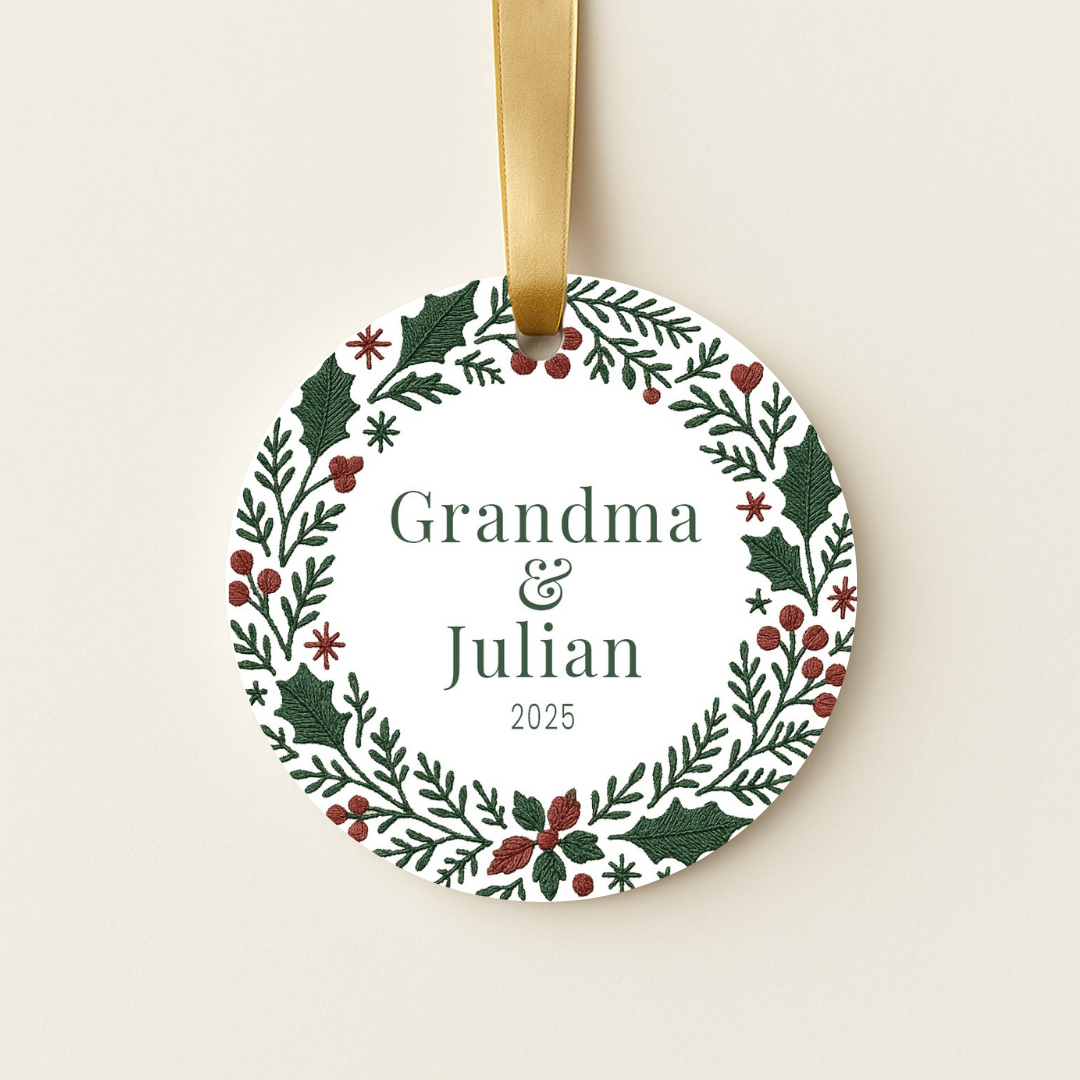 Round personalized Christmas ornament with a green and red embroidered wreath design