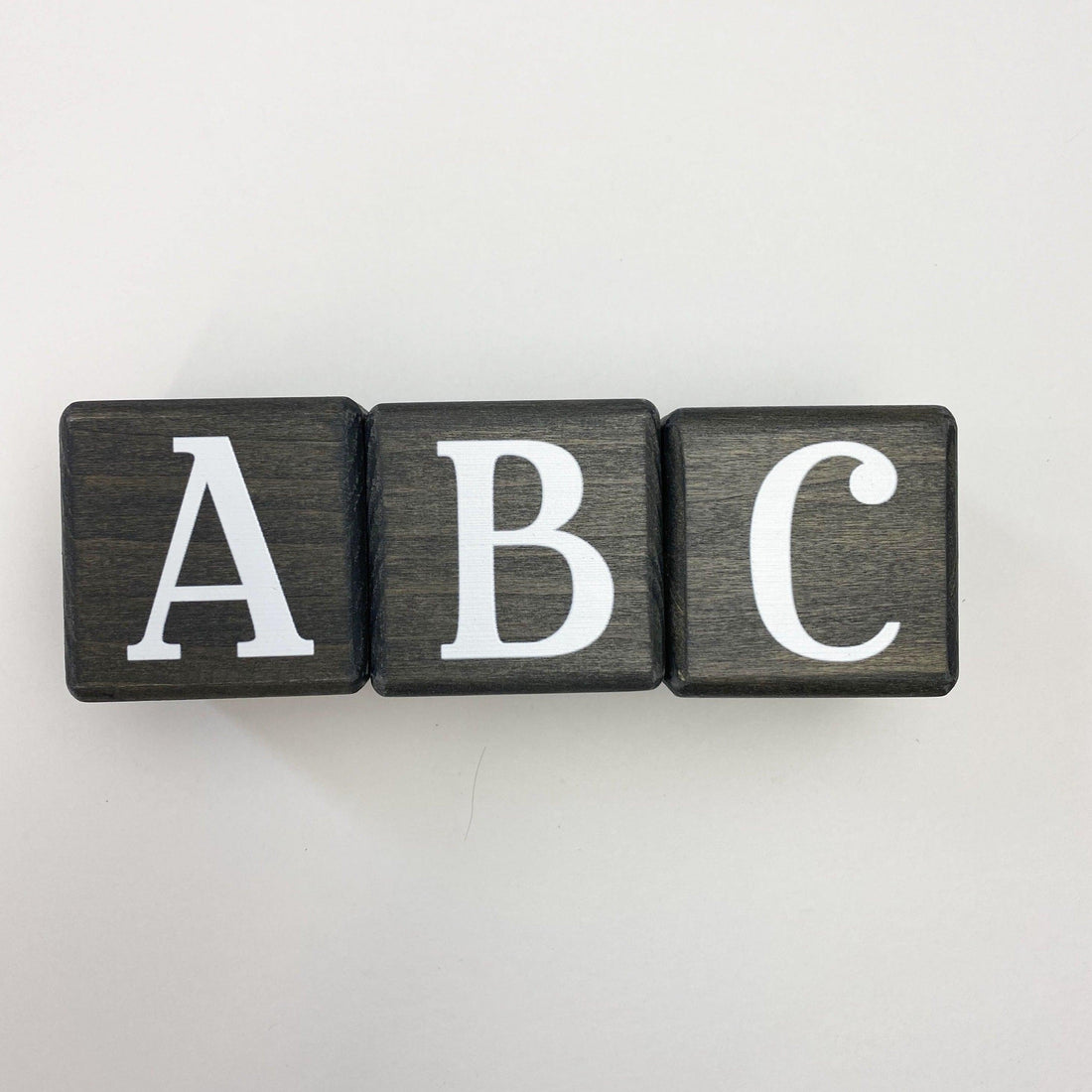 Wooden letter blocks in dark gray showing ABC