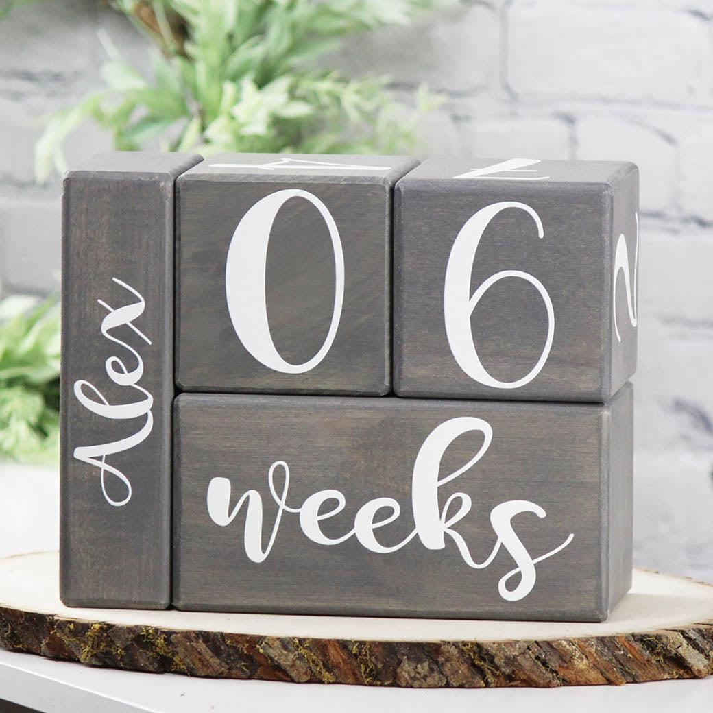 Wooden Birch baby milestone blocks in gray stain at 06 weeks with Alex name block