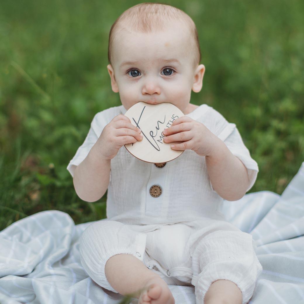 Baby holding 10 month milestone card