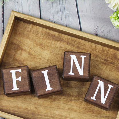 Wooden letter blocks in walnut spelling FINN