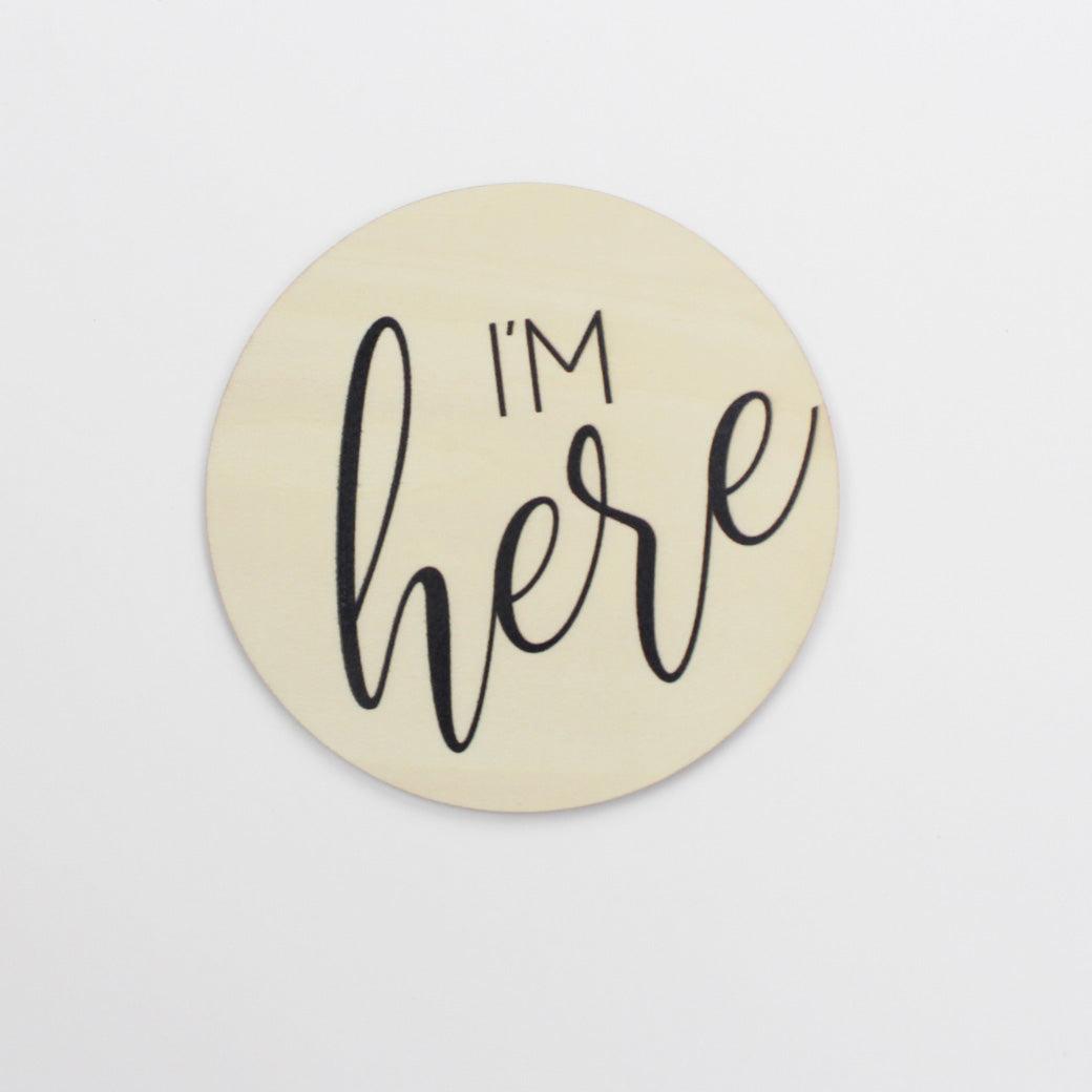 Birth announcement disc that says "I'm here"
