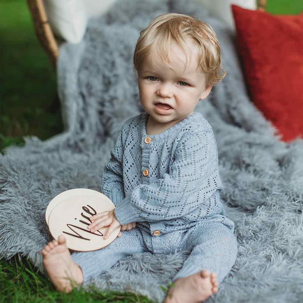 Baby holding sign showing he&