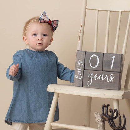 Baby standing beside Willow baby milestone blocks in gray stain at 01 years